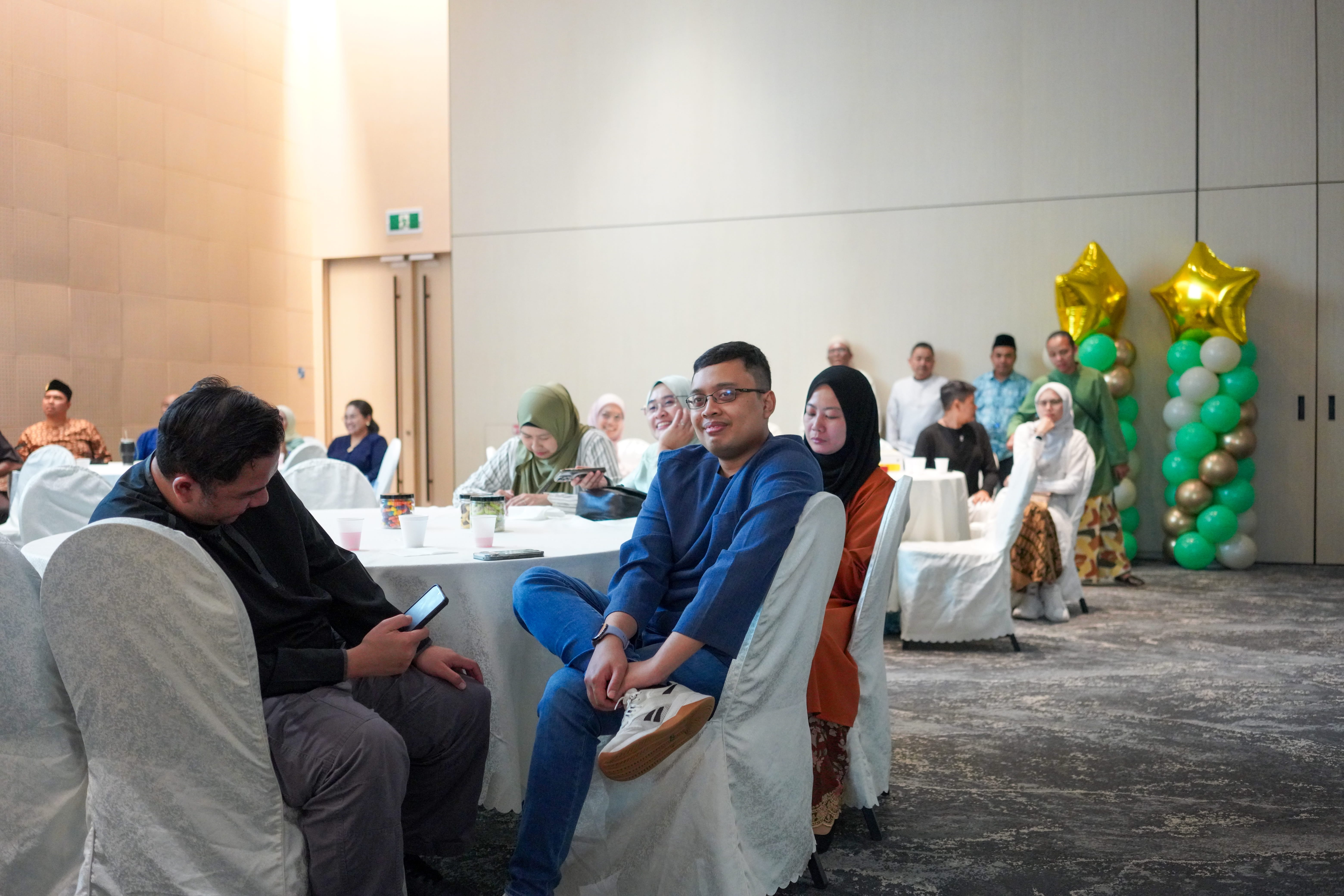 Guests seated at a table in the function hall awaiting commencement of the programme.